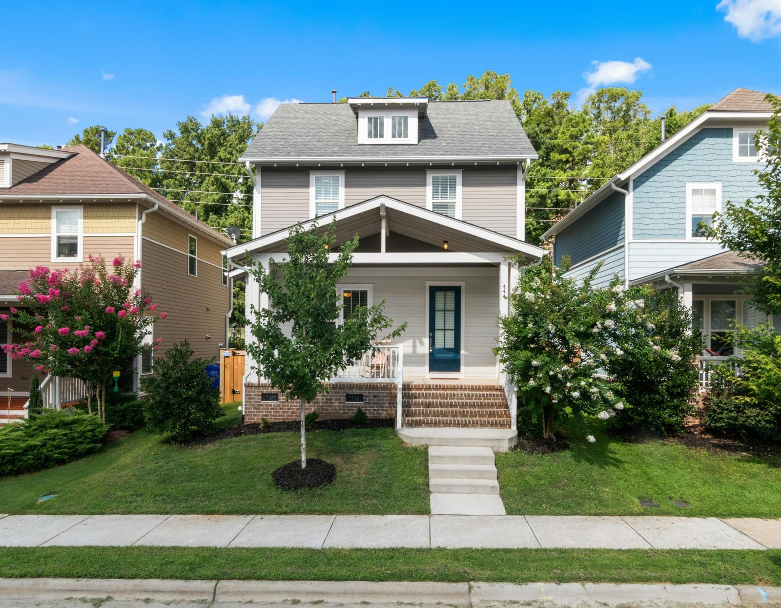 A beautiful suburban home with a well-maintained lawn and vibrant surroundings.