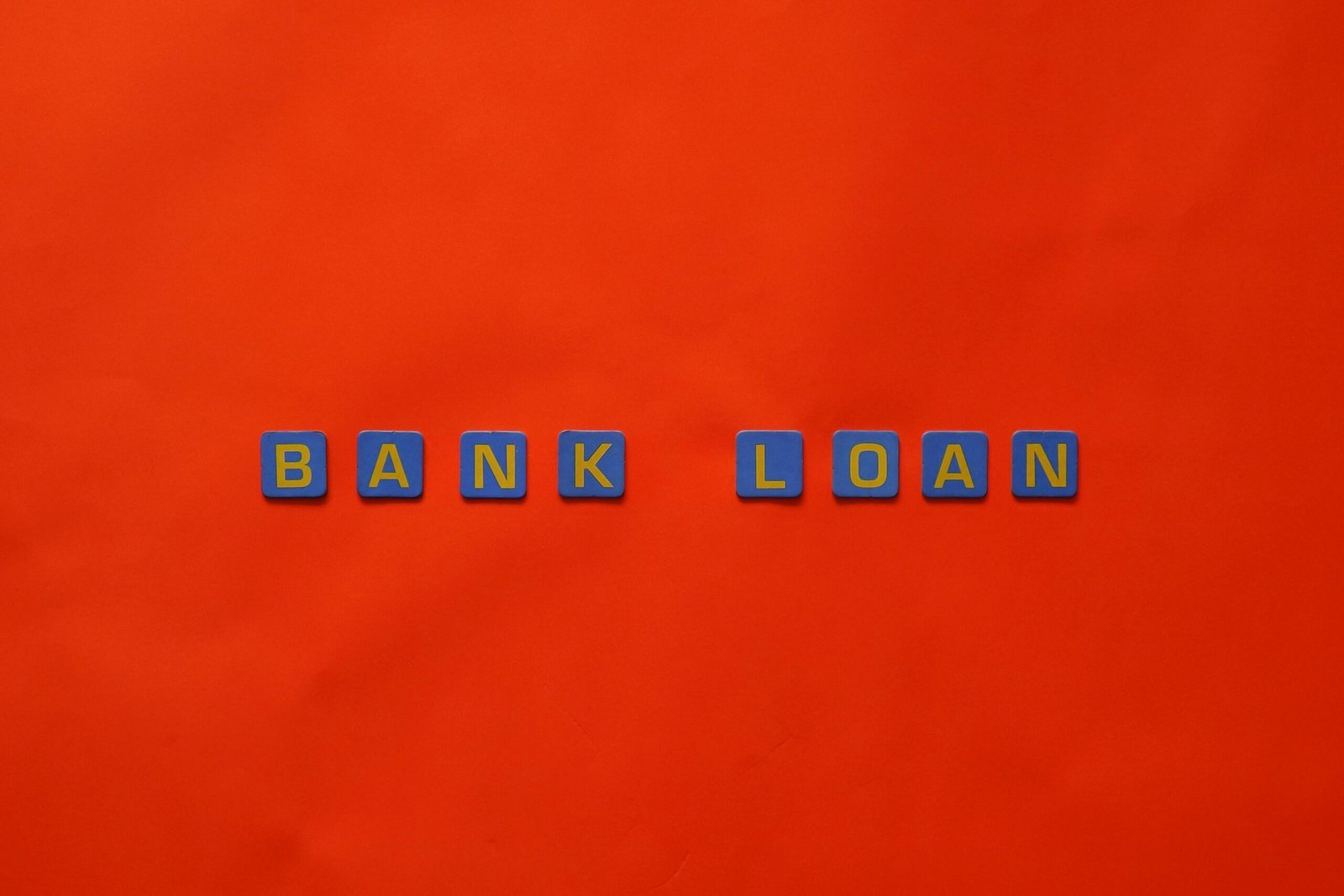 Letters forming 'Bank Loan' on a vibrant red surface, ideal for finance themes.